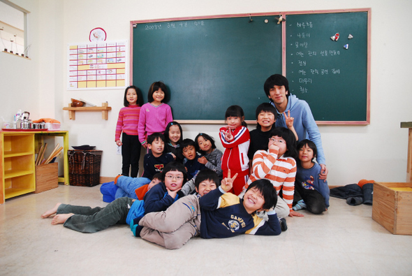초등 대안학교인 ‘무지개학교’ 2학년 학생들이 새학기를 맞아 선생님과 단체사진을 찍으며 활짝 웃고 있다. 무지개교육마을 제공