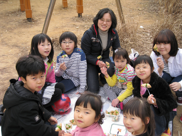 지난 10일 꿈마을학교 아이들이 마을 뒷산에 올라가 직접 만든 유부초밥을 먹으며 즐거워하고 있다.