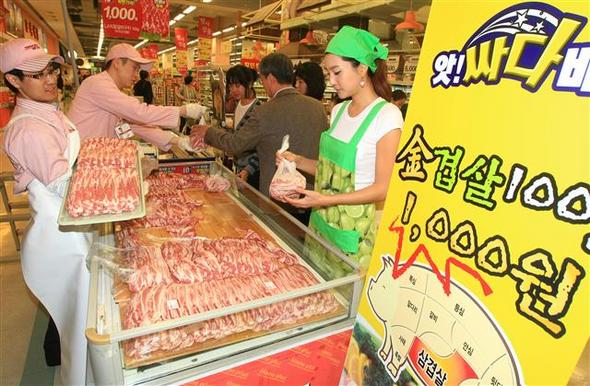 <b>삼겹살이 천원?</b>홈플러스 창립 10돌을 맞아 서울 영등포점에서 19일 열린 할인 행사에서 고객들이 삼겹살을 고르고 있다. 홈플러스는 이날부터 1주일 동안 국내산 삼겹살 100g을 반값인 1천원에 판매한다.  연합뉴스