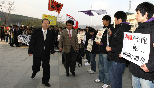 <b>경기대 학생들 “현승일 후보 사퇴하라”</b> 경기대 제8대 총장 후보로 입후보한 현승일 전 한나라당 의원(앞줄 왼쪽)이 1일 오후 경기 수원시 영통구 경기대 수원교정 텔레컨벤션센터 앞에서 소견발표회장으로 걸어가는 동안 학생들이 “교과부와 손종국 전 총장과 결탁한 현 후보는 사퇴하라”며 시위를 벌이고 있다.  수원/이종근 기자 root2@hani.co.kr