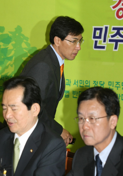 친노그룹의 대표격인 안희정 민주당 최고위원(위)이 8일 오전 국회에서 열린 최고위원회의 도중 걸려온 휴대전화를 받으려고 회의장을 나서고 있다. 아래 왼쪽부터 정세균 대표와 원혜영 원내대표. 
 김진수 기자 js@hani.co.kr