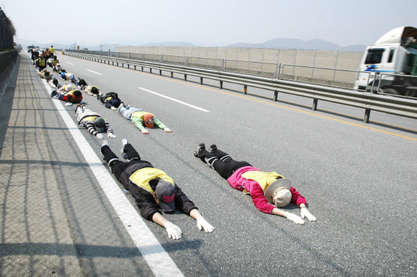 수경 스님과 문규현·전종훈 신부가 이끄는 오체투지 순례단이 지난 10일 공주시 정안면 23번 국도길에서 오체투지를 하고 있다. 오체투지 순례단 제공