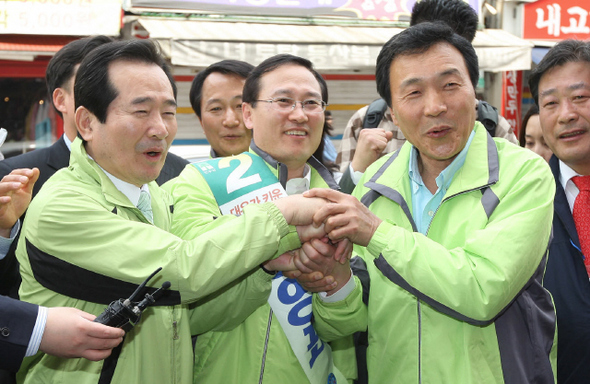 손학규 민주당 고문(오른쪽)이 칩거 9개월 만에 모습을 드러내 19일 오전 인천 부평구 산곡동 영아다방 네거리에서 정세균 민주당 대표(왼쪽)와 함께 홍영표 후보의 손을 잡은 채 지지를 호소하고 있다. 인천/김봉규 기자 bong9@hani.co.kr