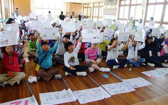 경남 사천시 남양초등학교 학생들이 학교에서 열린 ‘2009 이순신 사랑 캠프’에서 이순신 장군에 대한 문제가 나오자 답을 적어 들고 있다. 사천/연합뉴스