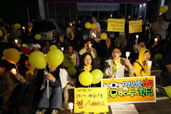 ‘노무현을 사랑하는 사람들의 모임’(노사모) 회원들이 30일 밤 서울 서초동 대검찰청 건너편에서 노란 풍선과 촛불을 든 채 노 전 대통령에 대한 조사가 끝나기를 기다리고 있다. 연합뉴스