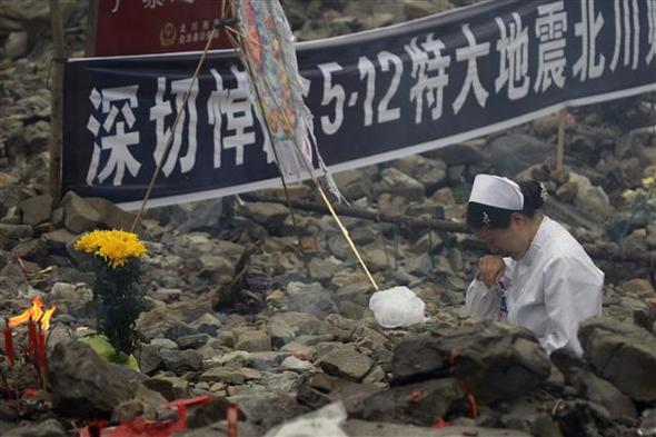 12일 중국 베이촨에서 한 간호사가 “진심으로 쓰촨 대지진 희생자들을 추모합니다”라고 적힌 펼침막 밑에서 울고 있다. 베이촨 지역 지진 생존자들은 이날 쓰촨 대지진 1돌을 맞아 피해 현장을 찾아, 희생자들을 추모했다. 베이촨/AP 연합