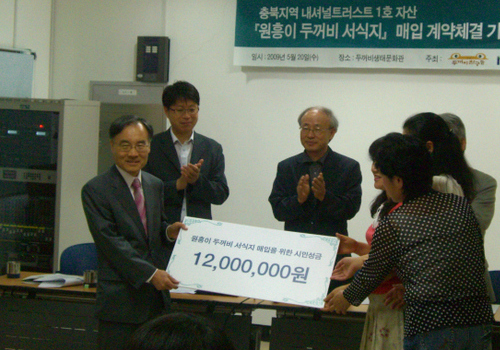   한국내셔널트러스트 양병이 이사장(왼쪽)과 환경 시민모임 두꺼비 친구들 회원들이 20일 ‘원흥이 방죽 두꺼비 서식지 매입을 위한 성금’으로 두꺼비 서식지 매입 계약을 했다. 두꺼비 친구들 제공.
