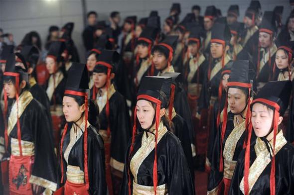  고대 학자의 복장을 입은 중국 학생들이 24일 중국 동부 안후이성 허페이에서 전통 성인식을 재연하고 있다. 최근 중국에서는 사회의 화합과 조화를 강조하는 전통 유교사상이 정부의 지원을 받으며 르네상스를 맞고 있다.  허페이/AFP 연합