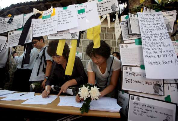 26일 오후 서울 덕수궁 앞 ‘시민 분향소’를 찾은 시민들이 노 전 대통령을 추모하는 글을 쓰고 있다. 이종찬 선임기자 <A href="mailto:rhee@hani.co.kr">rhee@hani.co.kr</A>