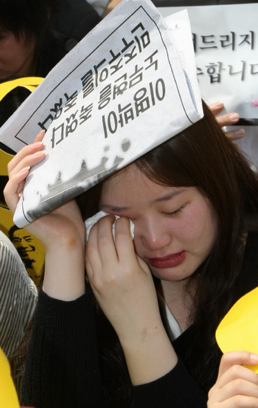 서울광장에서 노제가 진행되는 동안 한 시민이 눈물을 훔치고 있다.