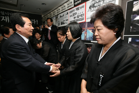 정세균 민주당 대표가 7일 오후 서울 용산구 남일빌딩 ‘용산참사’ 현장을 둘러본 뒤 희생자 유족을 만나 위로하고 있다.  김봉규 기자 <A href="mailto:bong9@hani.co.kr">bong9@hani.co.kr</A>