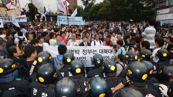 15일은 6·15 남북공동선언 채택 9돌이 되는 날이다. 6·15 공동선언은 반세기 냉전과 적대의 20세기 남북관계를 화해·협력과 탈냉전의 21세기 바다로 이끄는 ‘평화와 통일의 장전’이라는 평가를 받았다. 김대중 당시 대통령은 남북 정상회담 직후 “더 이상 한반도에 전쟁 위협은 없다”고 선언하기도 했다. 하지만 최근 한반도 정세는 일촉즉발의 위기 상황이다. ‘6·15 공동선언 9돌 범국민실천대회’를 마친 시민·사회단체 회원과 학생들이 14일 오후 행사장인 서울 중구 장충체육관 앞에서 거리행진을 하려 했으나, 경찰에 가로막혔다.  박종식 기자 <A href="mailto:anaki@hani.co.kr">anaki@hani.co.kr</A>