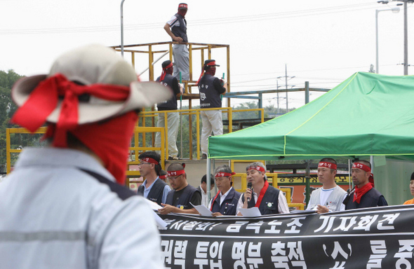 민주노총과 금속노조가 15일 오전 경기 평택시 칠괴동 쌍용차 공장에서 연 기자회견에서 정갑득(오른쪽 세번째) 금속노조 위원장이 “노-노 갈등을 유발해 공권력 투입 명분을 축적하려는 회사를 규탄한다”고 말하고 있다.   평택/신소영 기자 viator@hani.co.kr