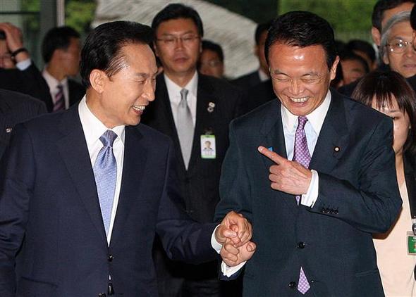 이명박 대통령(왼쪽)과 아소 다로 일본 총리가 28일 오후 일본 도쿄 총리관저에서 손을 맞잡고 밝은 표정으로 이야기하며 정상회담장으로 향하고 있다. 도쿄/연합뉴스