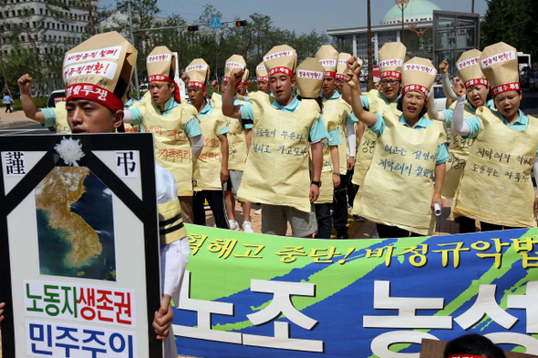  지난달 30일 해고된 보건의료노조 소속 비정규직 노동자들이 24일 오전 서울 여의도 국민은행 앞에서 위협받는 노동자의 생존권을 상징하는 상복을 입고 계약해지 철회와 정규직 전환을 촉구하는 구호를 외치고 있다.  김태형 기자 xogud555@hani.co.kr