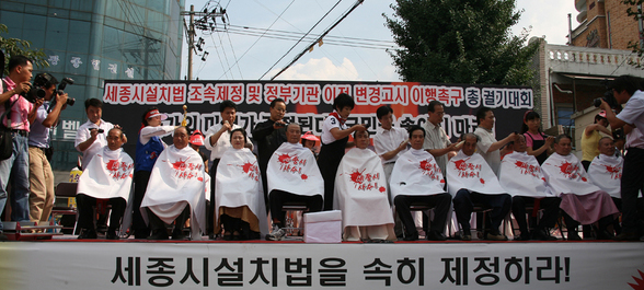 지난 30일 충남 연기군 조치원에서 열린 행정도시사수대회에 참석한 주민들이 결의를 다지는 삭발을 한 뒤 참가자들과 ‘행정도시 사수’ 구호를 외치고 있다.