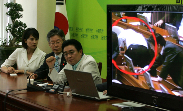 한나라당 대리투표 의혹 동영상 공개  전병헌 민주당 의원(맨 오른쪽) 등이 2일 오후 국회에서 지난달 22일 신문법 직권상정 처리 당시 한나라당의 대리투표 장면으로 의심되는 동영상을 공개하고 있다. 전 의원은 “오른쪽 화면의 동그라미 안 남성 의원이 다른 의원의 의석 아래쪽에 있는 버튼 쪽을 향해 허리를 숙이고 있어 대리투표를 하고 있는 것으로 의심이 간다”고 말했다.  이종찬 선임기자 <A href="mailto:rhee@hani.co.kr">rhee@hani.co.kr</A>