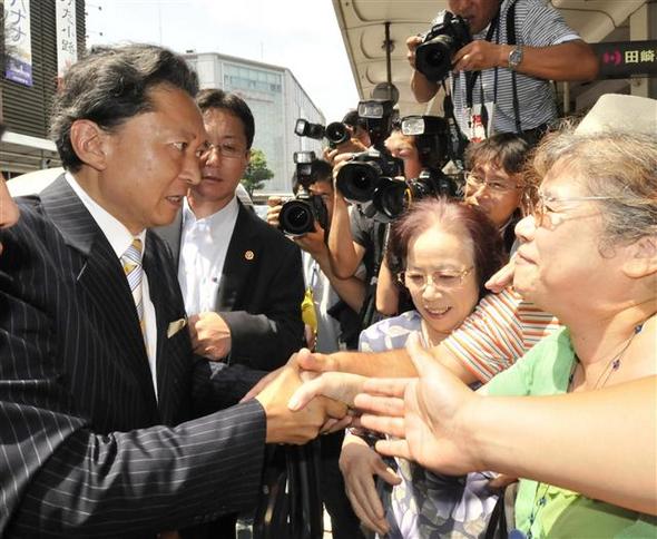 일본 민주당의 하토야마 유키오 대표(왼쪽)가 18일 교토에서 총선 유세 도중 지지자들의 손을 잡고 있다.  교토/AFP 연합