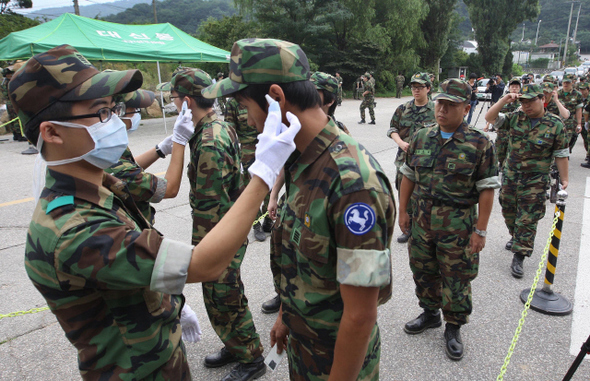  26일 오전 경기 고양시 덕양구 지축동 육군 56사단 훈련장에서 부대 장병들이 훈련을 받으러 온 예비군들을 상대로 ‘신종 인플루엔자 A’ 감염 여부를 확인하기 위해 체온을 재고 있다.   고양/신소영 기자 <A href="mailto:viator@hani.co.kr">viator@hani.co.kr</A>