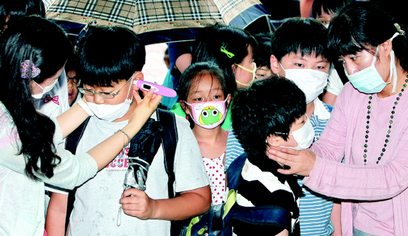 27일 오전 서울 용산구 이촌동 신용산초등학교에서 교사들이 ‘신종 인플루엔자 A’ 감염 여부를 확인하기 위해 마스크를 쓴 채 등교하는 학생들의 체온을 재고 있다. 정부는 모든 학교에서 날마다 등교하는 학생들을 대상으로 발열 검사를 하도록 했다. 이종근 기자 <A href="mailto:root2@hani.co.kr">root2@hani.co.kr</A>