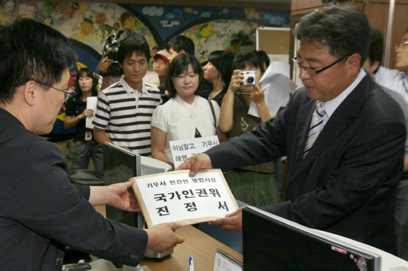 최석희 민주노동당 비상경제상황실장(오른쪽) 등 기무사의 사찰로 피해를 입었다고 주장하는 민간인 피해자들이 2일 오전 서울 중구 무교동길 국가인권위원회에 국군 기무사에 대한 조사와 구제를 신청하는 진정서를 내고 있다. 박종식 기자 anaki@hani.co.kr