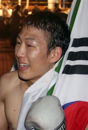 김지훈이 13일(한국시각) 열린 국제복싱기구(IBO) 슈퍼페더급 타이틀전에서 졸라니 마랄리를 케이오로 꺾은 뒤 태극기를 들고 기뻐하고 있다.  요하네스버그/연합뉴스