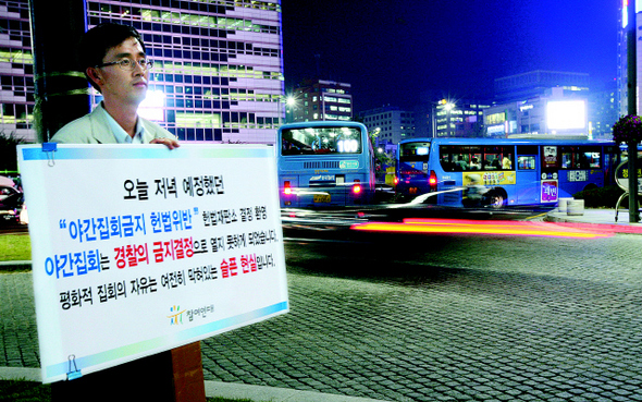 박근용 참여연대 사법감시센터 팀장이 25일 저녁 서울 청계광장에서 ‘야간 옥외집회 금지’ 조항에 대한 헌법재판소의 ‘헌법 불합치’ 결정에도 불구하고 경찰이 이날 참여연대가 낸 야간 집회를 불허 통보한 것에 항의하며 1인 시위를 벌이고 있다. 박종식 기자 <A href="mailto:anaki@hani.co.kr">anaki@hani.co.kr</A>