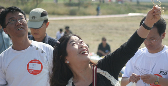 10일 한강시민공원 광나루지구 모형비행장에서 열린 ‘코리아컵 종이비행기 대회’에서 오래 날리기 부문에 출전한 한 여성 참가자가 비행기를 하늘 높이 쏘아 올리고 있다.