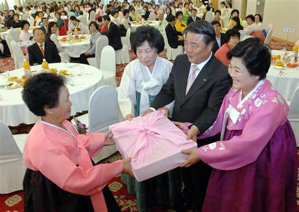  20일 오전 제주시 퍼시픽호텔에서 강택상 제주시장(가운데)과 문정복 제주시새마을부녀회 회장(오른쪽)이 70살 이상 된 할머니에게 수의를 전달하고 있다.  제주/연합뉴스
