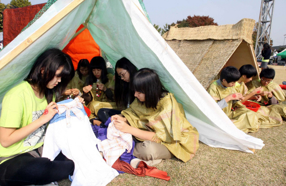 국제구호개발기구 월드비전이 마련한 ‘2009 기아체험 24시간’ 행사에 참가한 중·고생들이 23일 오후 서울 잠실운동장 보조경기장에 마련된 난민 텐트에서 헝겊을 이용해 옷을 만드는 등 난민체험을 하고 있다. 참가 학생들은 어린이노동, 난민노동 등을 체험하며 지구촌 빈곤문제에 공감하는 시간을 보냈다.  김태형 기자 xogud555@hani.co.kr
