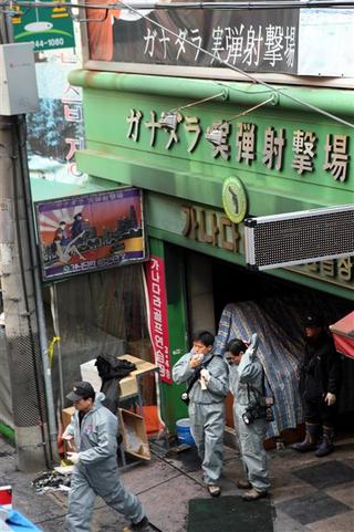 경찰이 15일 일본인 관광객 등 10명이 숨진 부산 중구 신창동 국제시장 안 실내 실탄사격장 화재 현장에서 감식을 한 뒤 밖으로 나오고 있다.  부산/연합뉴스