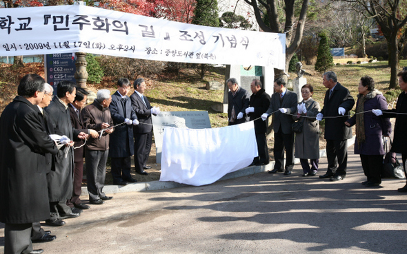  17일 서울대 교정에서 열린 ‘민주화의 길’ 조성식에서 고 박종철 열사의 아버지 박정기(가운데 오른쪽)씨와 이장무 서울대 총장(가운데 왼쪽) 등이 안내도 제막식을 하고 있다. 1.2㎞ 구간으로 만들어진 이 길에는 1960년 4·19혁명부터 1987년 6·29선언에 이르기까지 경찰 고문과 분신자살 등으로 숨진 서울대생 18명의 동상과 추모비가 세워졌다.  이종근 기자 <A href="mailto:root2@hani.co.kr">root2@hani.co.kr</A>