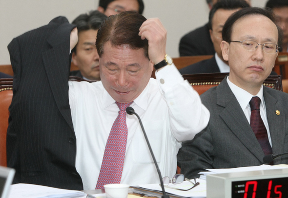 유명환 외교통상부 장관(왼쪽)이 20일 오전 국회에서 열린 외교통상통일위원회 전체회의에서 한－미 정상회담에 대한 의원들의 질문에 답변하던 중 웃옷을 벗고 옷차림을 추스른 뒤 다시 입고 있다. 오른쪽은 현인택 통일부 장관.   김진수 기자 jsk@hani.co.kr