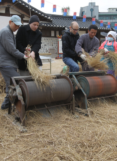 22일 오후 서울 중구 필동 남산골 한옥마을에서 열린 ‘2009 남산골 조상의 겨울나기 농경문화체험행사’에 구경온 외국 관광객들이 도움말을 들으며 탈곡기를 이용해 벼를 털어보고 있다. 이종근 기자 root2@hani.co.kr