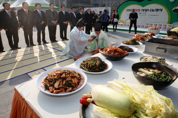 한국전통음식연구소와 농협 임직원들이 24일 오후 서울 광화문 광장에서 소외된 이웃들에게 나눠줄 김장 2009인분(20톤) 담그기 행사를 마친 뒤 그 김치를 세종대왕동상에 바치는 예를 진행하고 있다.  강재훈 선임기자 khan@hani.co.kr