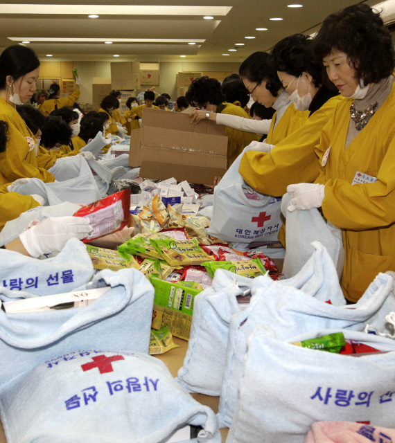 주한외교사절 부인, 장차관 부인, 적십자 여성봉사특별자문위원 등 150여명이 25일 오전 서울 중구 남산동 대한적십자사 본사 강당에서 어려운 이웃을 돕기 위한 ‘사랑의 선물’을 꾸러미에 담고 있다. 이날 제작된 사랑의 선물은 전국의 1700여 조손 가구, 2000여명의 홀몸노인들에게 전달될 예정이다.  김명진 기자 littleprince@hani.co.kr