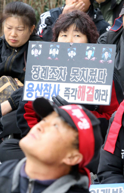 9일 오후 서울 구로구청 앞에서 열린 ‘서울시 개발지역 순회투쟁 결의대회’에 참가한 한 철거민이 손팻말을 든 채 한쪽을 물끄러미 바라보고 있다.  김태형 기자 xogud555@hani.co.kr