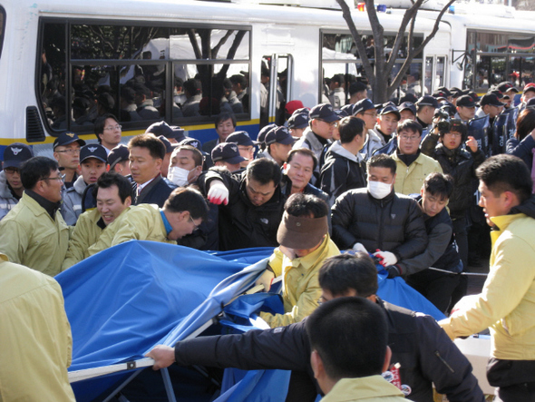 울산 남구 직원들이 예인선 노조원 및 민주노총 울산본부 조합원들과 울산시청 남문 옆에 설치된 천막 철거를 두고 밀고 당기기를 하고 있다.