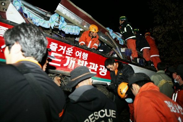 16일 오후 경북 경주시 현곡면 남사리 남사재 도로 옆 낭떠러지로 떨어져 찌그러진 버스에서 구조대원들이 부상자들을 구조하고 있다.  (연합뉴스)