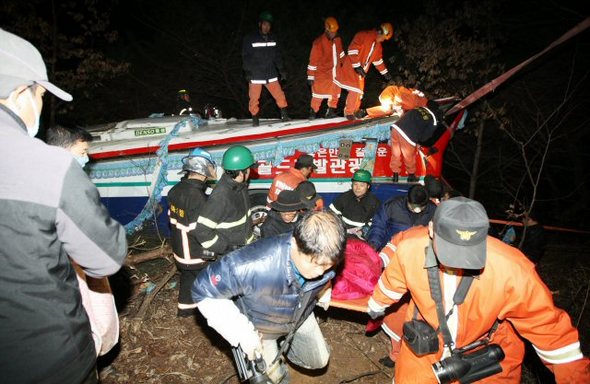 16일 오후 경북 경주시 현곡면 남사리 남사재 도로 옆 낭떠러지로 떨어져 찌그러진 버스에서 구조대원들이 부상자들을 구조하고 있다.  (연합뉴스)