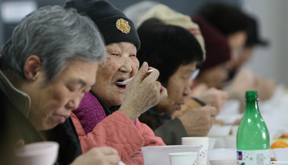  17일 낮 서울 노원구 상계동 중랑노원적십자봉사관에서 열린 ‘동지팥죽 큰잔치’에서 홀몸 노인과 새터민 등이 대한적십자사 서울지사 자원봉사자들이 마련한 팥죽을 들고 있다.  이종근 기자 root2@hani.co.kr