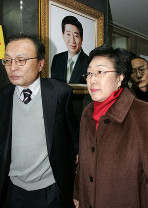 한명숙 전 총리가 18일 낮 서울 마포구 합정동 노무현재단 사무실에서 검찰의 체포영장 집행에 응해 검찰에 출석하려고 노무현 전 대통령의 사진이 걸려 있는 복도를 통해 밖으로 나가고 있다. 왼쪽은 이해찬 전 총리.  사진공동취재단