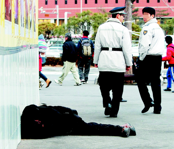 경찰이 22일 오후 서울역 앞 길에서 잠을 자고 있는 한 노숙인을 보고 지나치고 있다. 이날 서울역 앞에서는 2009년 거리에서 죽어간 노숙인들의 영정을 모아, 고인의 넋을 위로하는 추모제가 열렸다. 참가자들은 노숙인 지원 체계화를 위한 법률 및 안정적인 주거대책 마련을 촉구했다. 박종식 기자 <A href="mailto:anaki@hani.co.kr">anaki@hani.co.kr</A>   