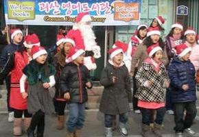 김정혜·레이먼드 잉그램(산타 복장) 부부가 무료로 운영하는 충북 괴산의 영어도서관 어린이 회원들이 24일 낮 시내 곳곳에서 성탄 축하 캐롤을 들려주고 있다.