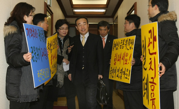 <b>금통위 앞에서 시위</b> 허경욱 기획재정부 차관(가운데)이 8일 오전 서울 남대문로 한국은행 본관 15층 복도에서 ‘기획재정부 차관의 금통위 참석은 관치금융 시도’라며 팻말 시위를 벌이고 있는 한은 노조원들 사이를 통과해 회의실로 들어가고 있다.  이종근 기자 root2@hani.co.kr