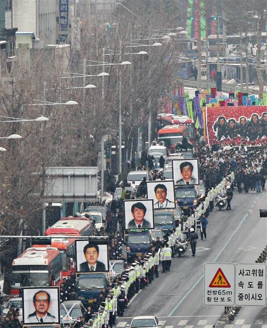 용산참사 철거민 희생자들의 범국민장 영결식이 열린 9일 고 이상림, 양회성, 한대성, 이성수, 윤용현 씨(앞에서부터)의 대형영정과 참석자들이 서울역에서 부터 용산 남일당 참사현장으로 행진하고 있다. 연합뉴스
