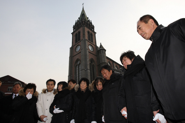 9일 오전 서울 중구 명동성당 들머리에서 박래군(오른쪽 셋째)·이종회(왼쪽 셋째) ‘용산참사 범국민대책위원회’ 공동집행위원장과 남경남 전국철거민연합 의장(맨오른쪽) 등 3명의 수배자와 유가족들이 손을 맞잡은 채 위로와 격려를 하고 있다. 김봉규 기자