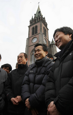 <b>수배 3인 자진출석</b> ‘용산참사’와 관련해 수배중인 박래군(오른쪽부터)·이종회 ‘용산참사 범국민대책위원회’ 공동집행위원장과 남경남 전국철거민연합 의장이 11일 오후 서울 명동성당 들머리에서 경찰에 자진 출석하기에 앞서 성당 쪽 인사의 격려를 받으며 밝게 웃고 있다. 김종수 기자 jongsoo@hani.co.kr