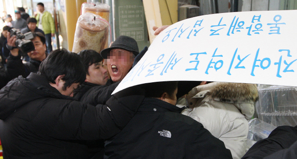 정운찬 총리가 16일 충남 연기군 조치원읍 중앙시장을 방문해 상인들을 만나는 동안, 한 주민이 ‘세종시 원안 추진’을 요구하는 구호를 외치다 경찰의 제지를 받고 있다.  연기/연합뉴스