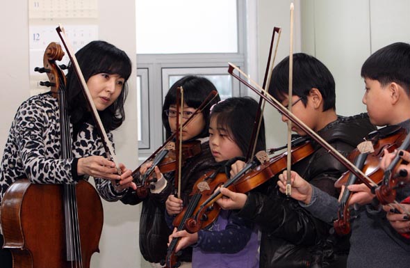  박경옥 한양대 관현악과 교수(맨왼쪽)가 18일 오전 서울시 성동구 행당동 성동구청소년수련관에서 ‘성동-한양 영재스쿨’ 음악반 아이들에게 바이올린을 가르치고 있다. 성동구와 한양대 지식봉사단 소속 교수들은 관내에 있는 아이들에게 국어·영어·수학·미술·음악 등 다양한 과목을 무료로 가르친다.  신소영 기자 viator@hani.co.kr